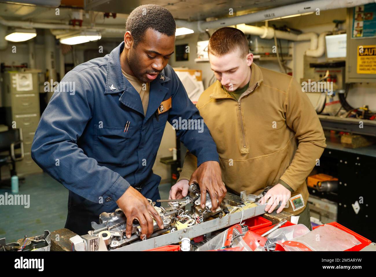 MARE DELLE FILIPPINE (17 febbraio 2022) Lance CPL. Sean Weber, di Oxford, Penn., assegnato ai “Cavalieri neri” di Marine Fighter Attack Squadron (VMFA) 314, destra, E Aviation Ordnanceman 3rd Class Domonique Addison, di Quitman, GA., assemblare un'unità rack bomba nel negozio di ordigni a bordo della portaerei di classe Nimitz USS Abraham Lincoln (CVN 72). Abraham Lincoln Strike Group è in programma di implementazione nell'area delle operazioni della flotta 7th degli Stati Uniti per migliorare l'interoperabilità attraverso alleanze e partnership, mentre funge da forza di pronto intervento a sostegno di un libero e aperto Indo-Paci Foto Stock