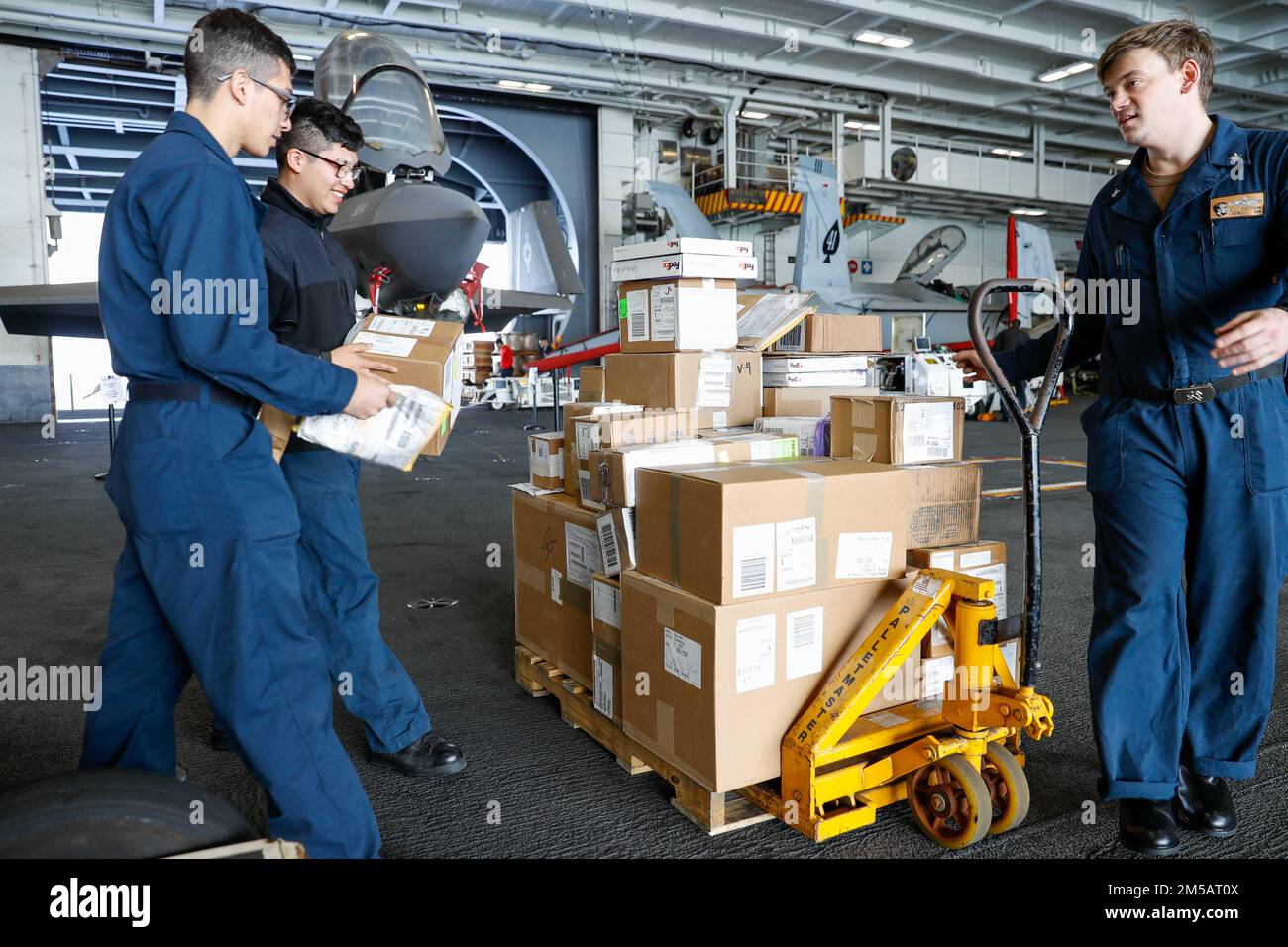 MARE DELLE FILIPPINE (17 febbraio 2022) i marinai organizzano il carico nella baia dell'hangar a bordo della portaerei di classe Nimitz USS Abraham Lincoln (CVN 72). Abraham Lincoln Strike Group è in fase di implementazione pianificata nell'area delle operazioni della flotta 7th degli Stati Uniti per migliorare l'interoperabilità attraverso alleanze e partnership e al tempo stesso fungere da forza di risposta pronta a sostegno di una regione indomPacifico libera e aperta. Foto Stock