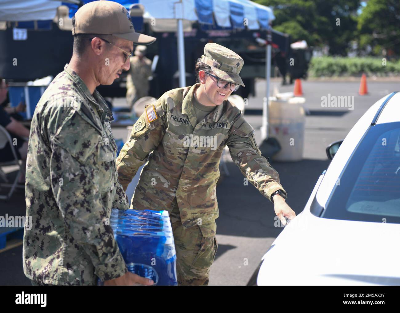 HONOLULU, Hawaii (17 febbraio 2022) – USA Navy Electronics Technician (Nuclear) 1st Classe Andrew Loera, assegnato al Naval Sea Systems Command e agli Stati Uniti Lyndsee Fielding, assegnato alla 57th Compagnia di polizia militare, 728th Battaglione di polizia militare, 8th Brigata di polizia militare, distribuisce l'acqua alla stazione di distribuzione idrica di Moanalua Terrace. STATI UNITI Navy sta lavorando a stretto contatto con il Dipartimento della Salute delle Hawaii, Stati Uniti Environmental Protection Agency e gli Stati Uniti Esercito per ripristinare l'acqua potabile sicura alle comunità abitative di Joint base Pearl Harbor-Hickam attraverso il campionamento e il lavaggio Foto Stock