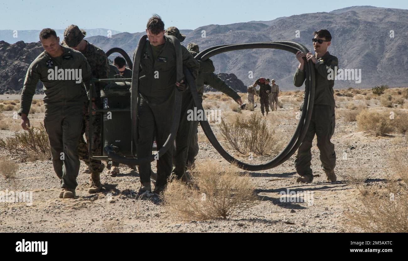 Marines con Marine Wing Support Squadron 372, Marine Aircraft Group (MAG) 39, 3rd Marine Aircraft Wing (MAW) e Marine Light Attack Helicopter Squadron 169, MAG 39, 3rd MAW, tubi flessibili carburante per il trasporto, una pompa carburante, E un filtro per la vescica che è atterrato in un Joint Precision Aerial Delivery System (JPADS) al Marine Corps Air Ground Combat Center Twentynine Palms, California, 16 febbraio 2022. Il carico del JPADS ha tenuto una camera d'aria del combustibile affinchè Marines stabilisca un punto di rifornimento di armamento anteriore all'atterraggio per mostrare l'aeroplano come self-serving negli ambienti austeri durante la Furia di inverno 22. Inverno Fury 22 stres Foto Stock