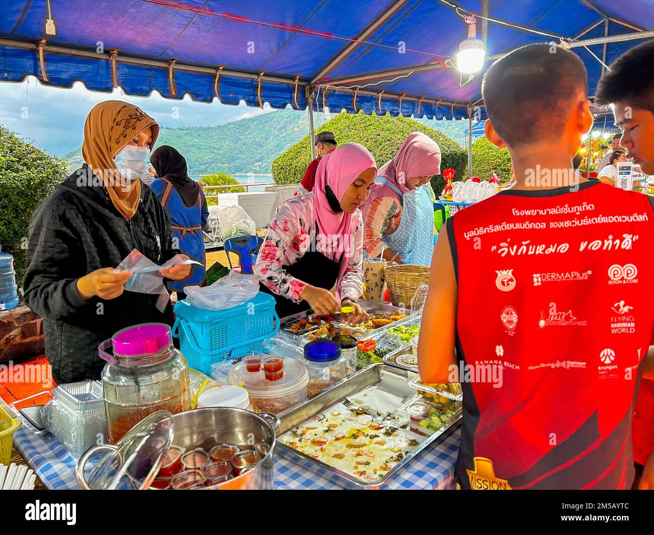 Mueang, Isola di Phuket, Thailandia, Donne musulmane che vendono cibo di strada tailandese al National Constitution Day evento, 12 dicembre 2022 Foto Stock