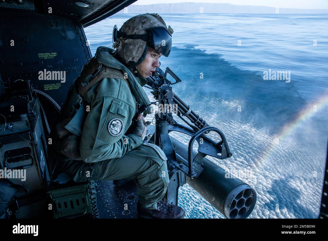 STATI UNITI William Ton, un capo di equipaggio assegnato a Marine Attack Light Attack Helicopter Squadron 469, Marine Aircraft Group 39, 3rd Marine Aircraft Wing (MAW), informa i piloti della loro distanza da un Craft di supporto di gamma durante una visita in elicottero, bordo, Ricerca, E l'esercizio di addestramento al sequestro su una UH-1Y Venom al largo della costa di San Clemente Island, California, 17 febbraio 2022. Winter Fury 22 offre ai Marines di 3rd MAW opportunità di formazione realistiche e pertinenti necessarie per rispondere a qualsiasi crisi in tutto il mondo e vincere in modo decisivo in un conflitto marittimo altamente contestato. Foto Stock