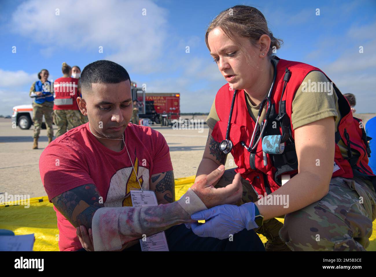 NEGLI STATI UNITI Airman del 6th Medical Group (a destra) applica un involucro medico a una vittima simulata durante un esercizio di risposta agli incidenti rilevanti (MAIN Accident Response Exercise, MARE) presso la base aeronautica di MacDill, Florida, 17 febbraio 2022. A MARE è un esercizio volto a replicare un'emergenza reale per gli Airmen che si allenano in un ambiente controllato. Foto Stock