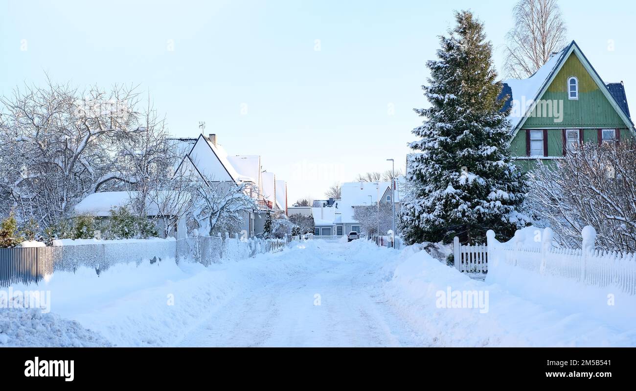 Paesaggio fiabesco invernale sulla strada con case con un tetto triangolare e strade ricoperte di molta neve Foto Stock
