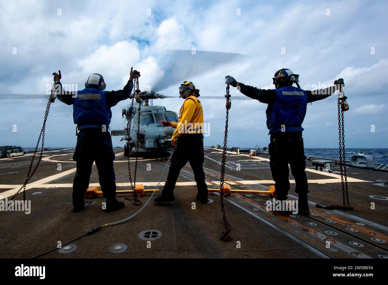 MARE DELLE FILIPPINE (18 febbraio 2022) i marinai si preparano a lanciare un elicottero MH-60R Sea Hawk, assegnato ai “Raptors” dell’elicottero Maritime Strike Squadron (HSM) 71, dal ponte di volo del cacciatorpediniere missilistico guidato di classe Arleigh Burke USS Spruance (DDG 111). Abraham Lincoln Strike Group è in fase di implementazione pianificata nell'area delle operazioni della flotta 7th degli Stati Uniti per migliorare l'interoperabilità attraverso alleanze e partnership e al tempo stesso fungere da forza di risposta pronta a sostegno di una regione indomPacifico libera e aperta. Foto Stock