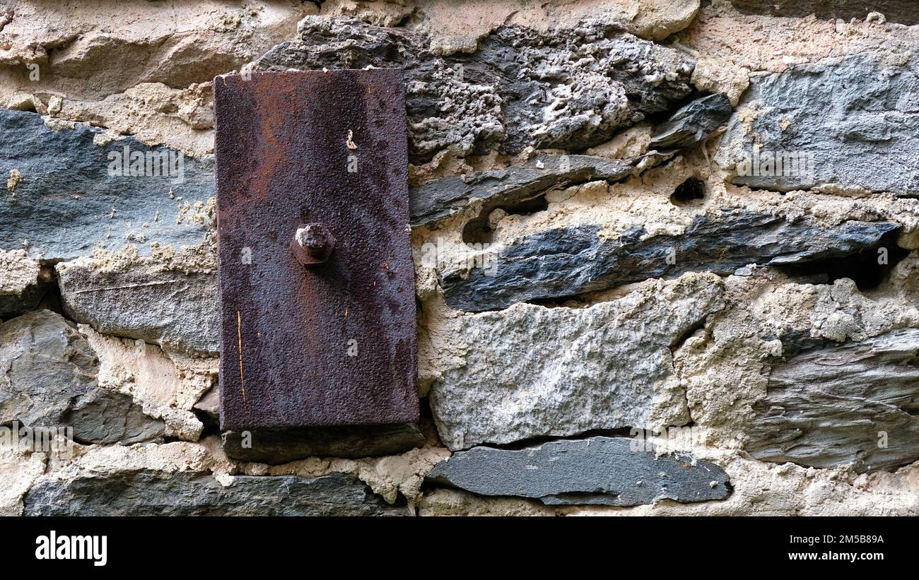 Ferro arrugginito costruzione ancora e pietra vecchia e mortaio. Foto Stock
