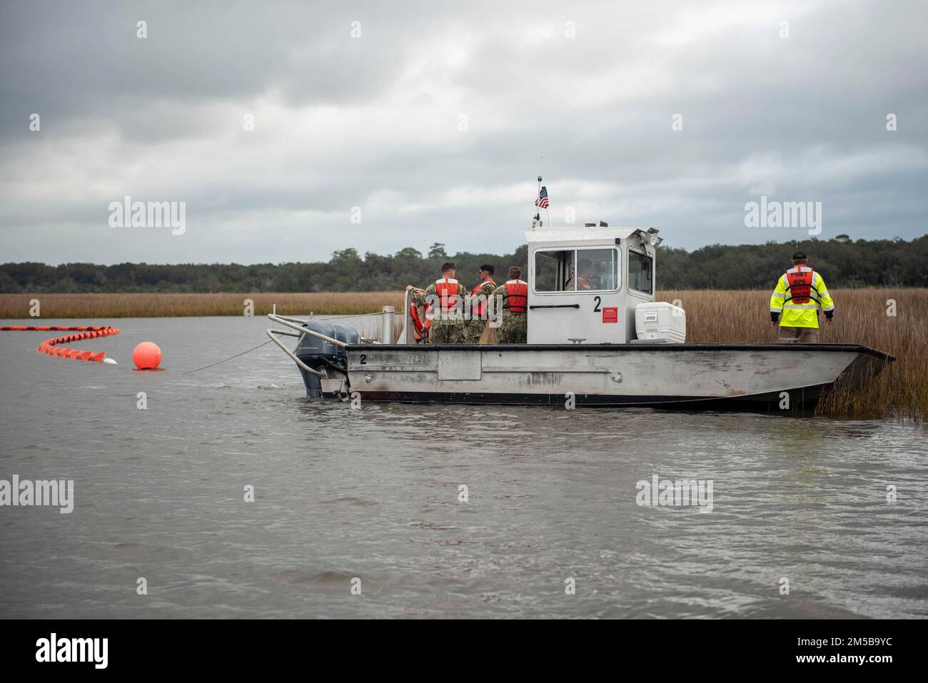 220218-N-KG461-1308 Kings Bay, GA. (18 febbraio 2022) Un'imbarcazione utilitaria con la base navale sottomarina Kings Bay Port Operations Division trascina un braccio di contenimento delle fuoriuscite di petrolio durante un esercizio di addestramento per la risposta alle fuoriuscite di carburante. Kings Bay ospita sei sottomarini missilistici balistici di classe Ohio che costituiscono la gamba più superstite della triade nucleare. Foto Stock