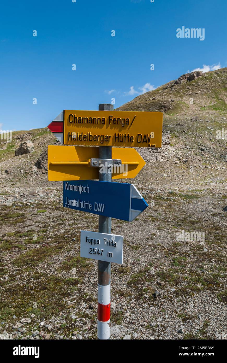 Panoramica generale con varie indicazioni stradali lungo il tragitto dal rifugio Jamtal in Austria al rifugio Heidelberger in Svizzera, che conduce gli escursionisti al passo Kronenjoch e al confine internazionale tra Austria e Svizzera per guidare gli escursionisti Trekking nelle Alpi Silvretta delle montagne austriaca e svizzera. Foto Stock