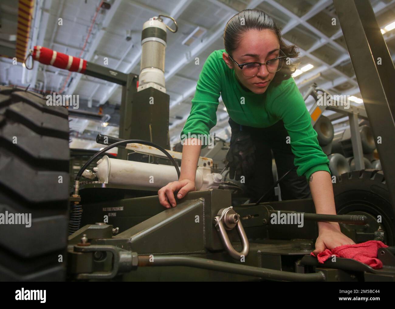 PHILIPPINE SEA (19 febbraio 2022) Aviation Support Equipment Technician 3rd Class Dakota Morales, di Panama City Beach, Fla., effettua una manutenzione positiva su un trattore nella baia di hangar a bordo della portaerei di classe Nimitz USS Abraham Lincoln (CVN 72). Abraham Lincoln Strike Group è in fase di implementazione pianificata nell'area delle operazioni della flotta 7th degli Stati Uniti per migliorare l'interoperabilità attraverso alleanze e partnership e al tempo stesso fungere da forza di risposta pronta a sostegno di una regione indomPacifico libera e aperta. Foto Stock