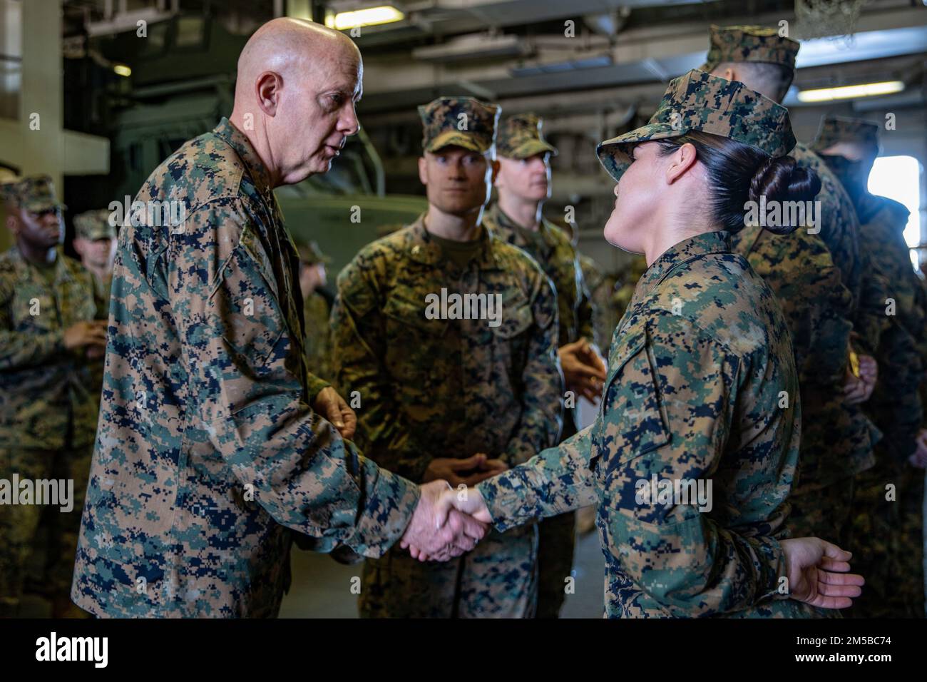 PEARL HARBOR (20 FEBBRAIO 2022) USA David Berger, il comandante del corpo dei Marine, scuote le mani con il CPL. Deanny Camacho, un capo di fornitura assegnato a Combat Logistics Battaglione 11, 11th Marine Expeditionary Unit (MEU), durante una visita distinta a bordo di una nave d'assalto anfibio di classe Wasp USS Essex (LHD 2), 20 febbraio 2022. I marinai e i marines dell'Essex Amphhibious Ready Group (ARG) e del 11th MEU visitano la base comune Pearl Harbor-Hickam mentre operano nella flotta degli Stati Uniti 3rd. Foto Stock