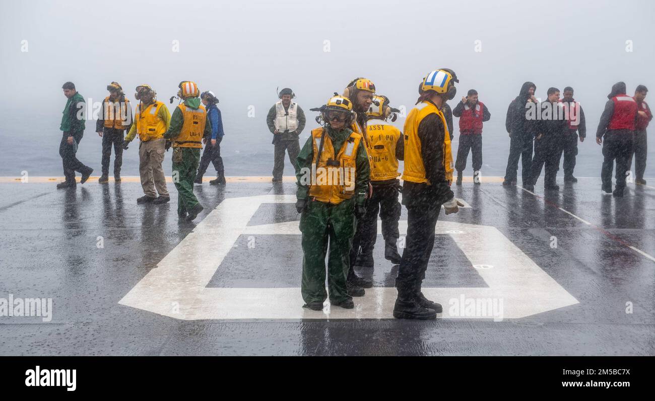 MARE DELLE FILIPPINE (19 febbraio 2022) i marinai assegnati alla nave d'assalto anfibio USS America (LHA 6), dispiegata in avanti, rimuovono i detriti dal ponte di volo della nave. L'America, nave guida dell'America Amphibious Ready Group, insieme alla Marine Expeditionary Unit 31st, opera nell'area di responsabilità della flotta statunitense 7th per migliorare l'interoperabilità con alleati e partner e fungere da pronta forza di risposta per difendere la pace e la stabilità nella regione dell'Indo-Pacifico. Foto Stock