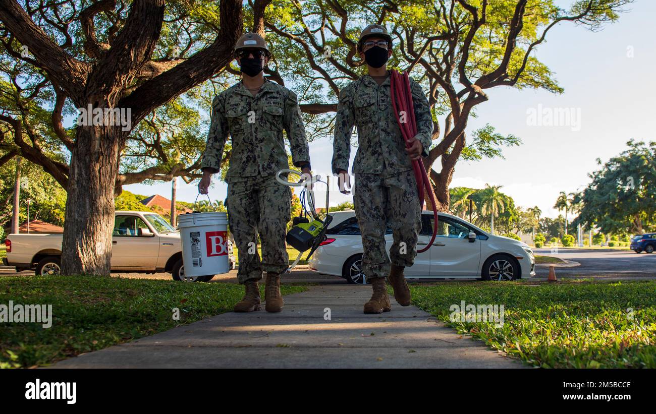 BASE CONGIUNTA PEARL HARBOR-HICKAM (19 febbraio 2022) – Construction Mechanic 2nd Class Matias Jimenez, a sinistra, e Builder 3rd Class Sergio Vidrio, assegnato alla Construction Battalion Maintenance Unit (CBMU) 303, camminano verso una base congiunta Pearl Harbor-Hickam (JBPHH) casa residente per valutare la qualità dell'acqua. Gli Stati Uniti Navy sta lavorando a stretto contatto con il Dipartimento della Salute delle Hawaii, Stati Uniti Environmental Protection Agency e gli Stati Uniti Esercito per ripristinare l'acqua potabile sicura alle comunità abitative di Joint base Pearl Harbor-Hickam attraverso il campionamento e il lavaggio, e il recupero del pozzo di Red Hill. Per informazioni dettagliate Foto Stock