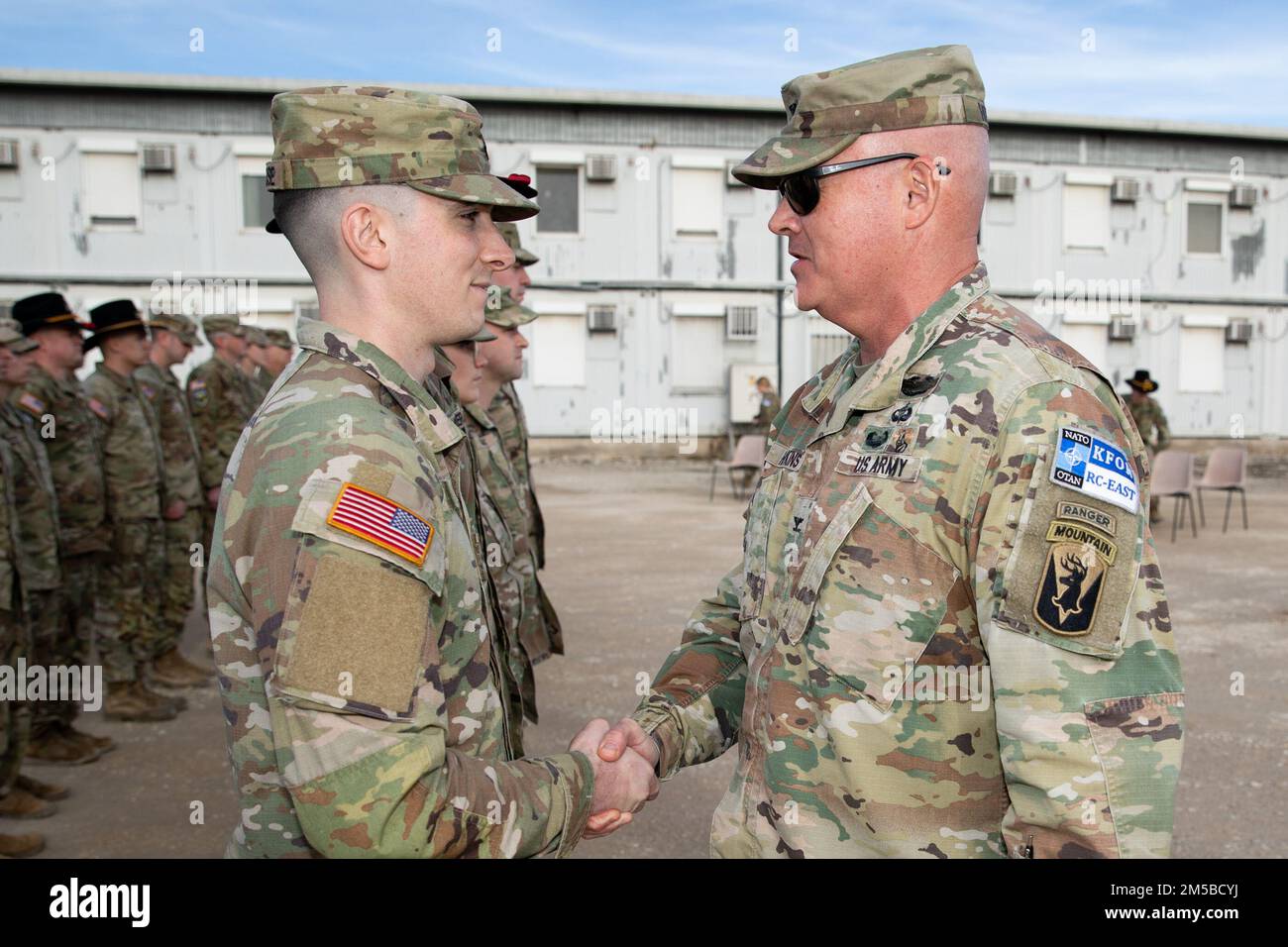 STATI UNITI Joseph Hopkins, comandante, Kossovo Force Regional Command-East, si congratula e ringrazia gli Stati Uniti Tyler Whitehouse, quartier generale, quartier generale, 1st Squadrone, 172nd Reggimento Cavalleria (montagna), durante la cerimonia di fine tour, Camp Novo Selo, Kosovo, 19 febbraio 2022. (STATI UNITI Foto dell'esercito del personale Sgt. Barbara Pendl) Foto Stock