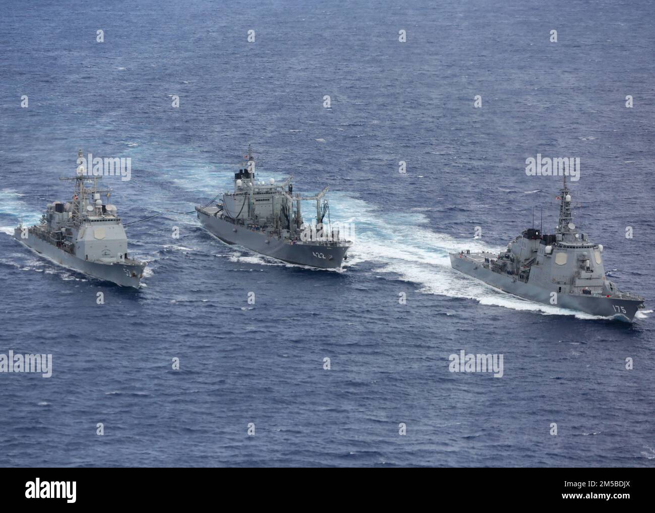 MARE DELLE FILIPPINE (20 febbraio 2022) Japan Maritime Self-Defense Force (JMSDF) olio di rifornimento di classe Towada JS Towada (AOE 422), centrale, rifornimento di carburante incrociatore missilistico guidato di classe Ticonderoga USS Mobile Bay (CG 53), a sinistra, mentre il cacciatorpediniere missilistico guidato JMSDF JS Myoko (DDG 175) si allontana. Abraham Lincoln Strike Group è in fase di implementazione pianificata nell'area delle operazioni della flotta 7th degli Stati Uniti per migliorare l'interoperabilità attraverso alleanze e partnership e al tempo stesso fungere da forza di risposta pronta a sostegno di una regione indomPacifico libera e aperta. Foto Stock
