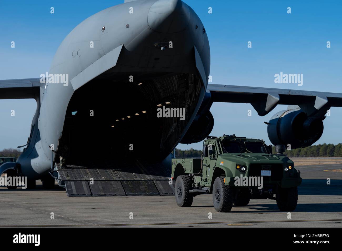 Durante l'esercizio fisico slimy Griffin presso Joint base McGuire-Dix-Lakehurst, New Jersey, 12-15 dicembre 2022, Un C-17 Globemaster III è caricato con un Joint Light Tactical Vehicle (JLTV) Utility. L'obiettivo del sottile Griffin è valutare la capacità, la capacità e la prontezza della forza totale per eseguire la missione di apertura della base aerea in un ambiente di guerra chimica simulato. (STATI UNITI Air Force foto di Senior Airman Faith Iris MacIlvaine) Foto Stock