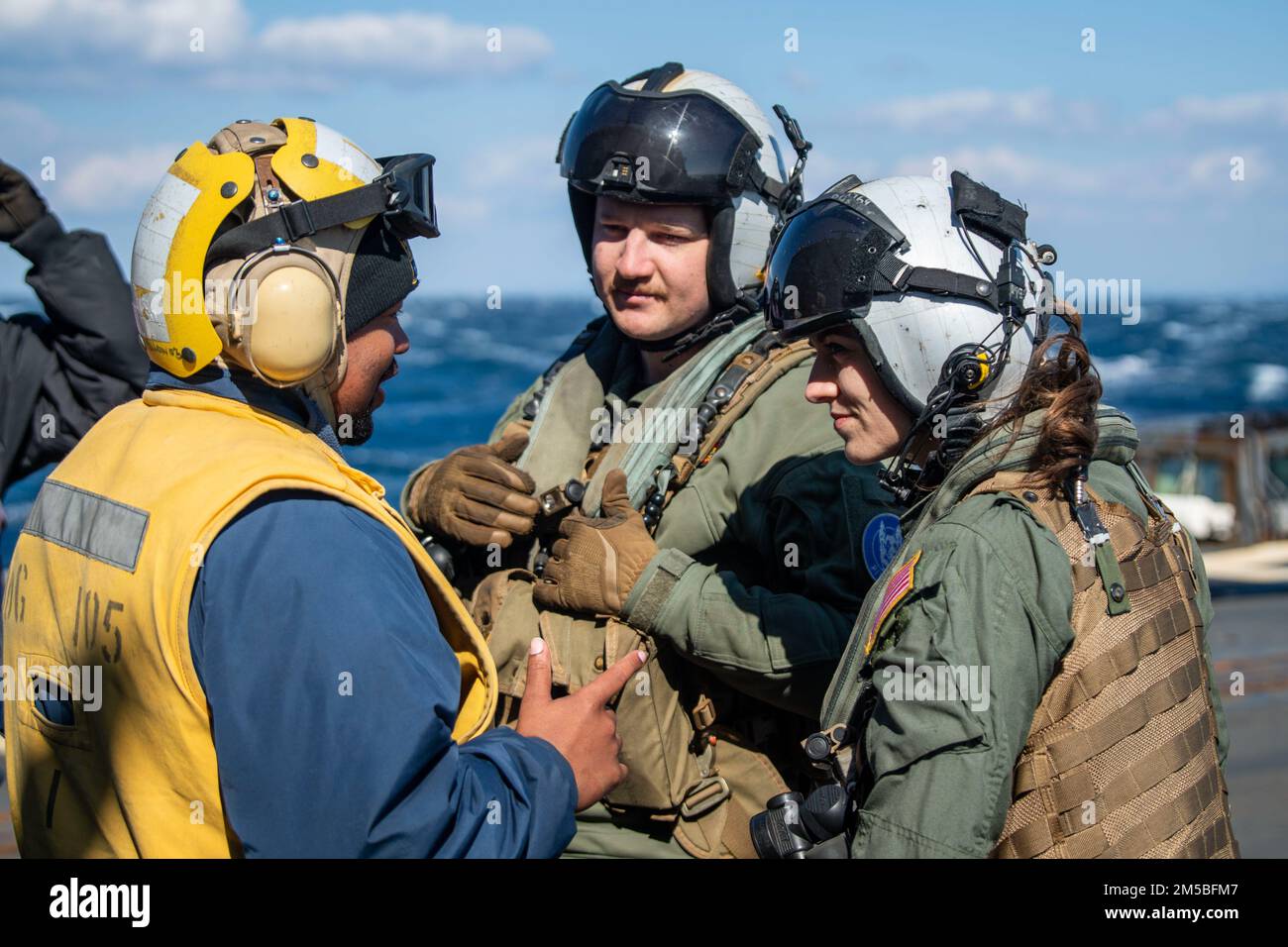 PACIFIC OCEAN (22 febbraio 2022) Boatswain’s Mate 3rd Class Kameron Clinton, a sinistra, da Eustis, Florida, assegnato al cacciatorpediniere missilistico guidato di Arleigh Burke-class USS Dewey (DDG 105), parla con Naval Air Crewman (elicottero) 2nd Class Baldwin Switzer, da Ocala, Florida, E la Lt. Olivia Czerewko, di Lemoore, California, assegnata all'Helicopter Maritime Strike Squadron (HSM) 51, prima delle operazioni di volo. Dewey è assegnato a Destroyer Squadron (DESRON) 15 e sta supportando un Indo-Pacific libero e aperto. CTF 71/DESRON 15 è il più grande DESRON della Marina e il 7th F degli Stati Uniti Foto Stock