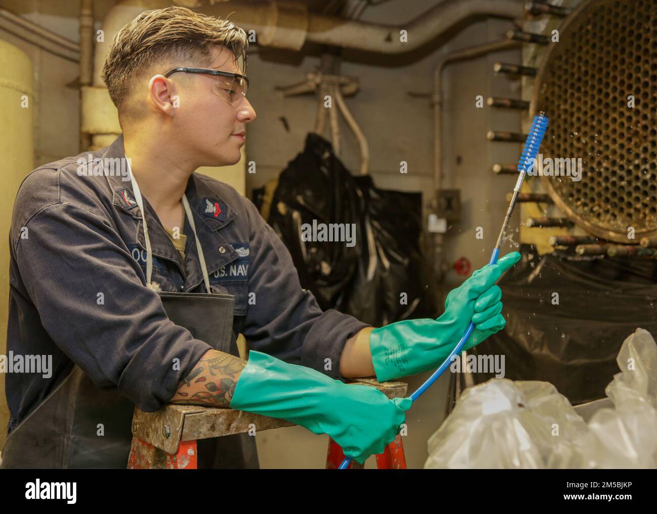 MARE DELLE FILIPPINE (23 febbraio 2022) il compagno di macchina 2nd Classe Andres Cloca, di San Antonio, Texas, pulisce un condensatore d'acqua utilizzando una lancia a bordo della portaerei di classe Nimitz USS Abraham Lincoln (CVN 72). Abraham Lincoln Strike Group è in fase di implementazione pianificata nell'area delle operazioni della flotta 7th degli Stati Uniti per migliorare l'interoperabilità attraverso alleanze e partnership e al tempo stesso fungere da forza di risposta pronta a sostegno di una regione indomPacifico libera e aperta. Foto Stock