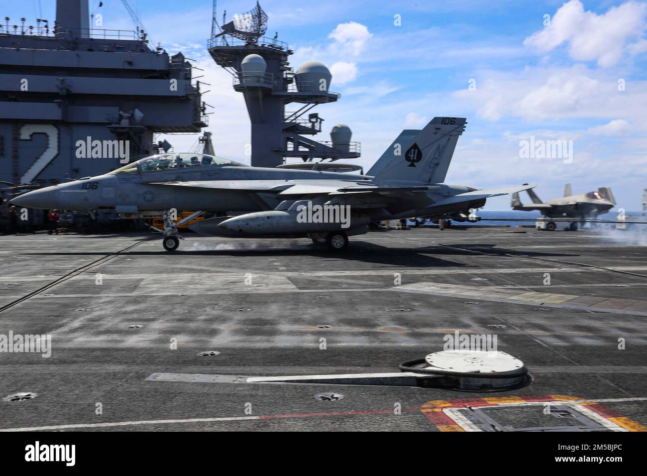 MAR DELLE FILIPPINE (Feb 23, 2022) Capt. Michael Langbehn, comandante, Carrier Air Wing (CVW) 9, Brian A. Ribota, commodore, Destroyer Squadron 21, fa un atterraggio arrestato in un F/A-18F Super Hornet, assegnato al 'Black Aces' di Strike Fighter Squadron (VFA) 41, sul ponte di volo del vettore aereo di classe Nimitz USS Abraham Lincoln (CVN 72). Abraham Lincoln Strike Group è in fase di implementazione pianificata nell'area delle operazioni della flotta USA 7th per migliorare l'interoperabilità attraverso alleanze e partnership, fungendo da forza di risposta pronta a supportare un indoPacif libero e aperto Foto Stock