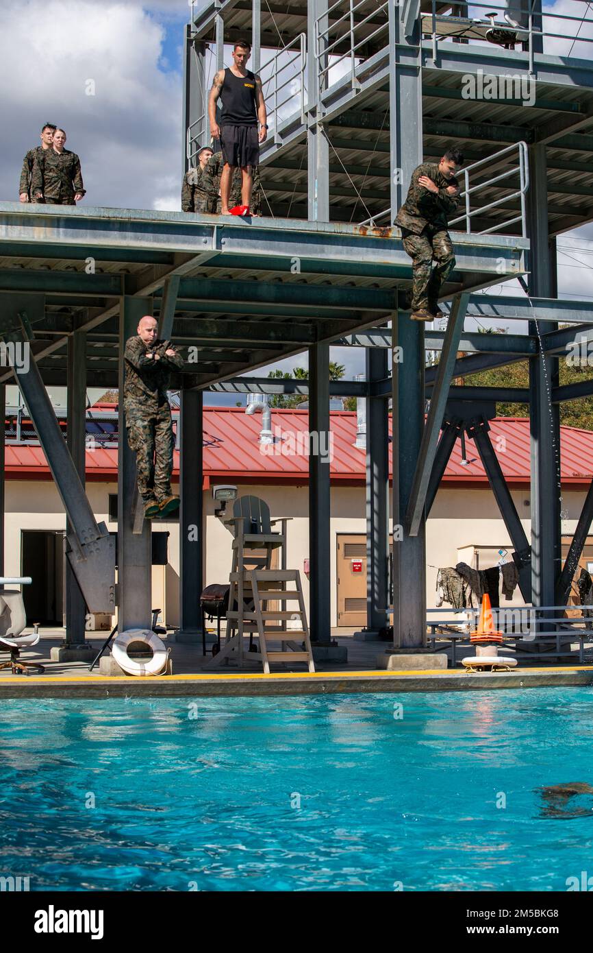 STATI UNITI Marines con i Marine Expeditionary Force Information Group, scendi dalla torre di 10 metri durante una nuotata di base al Marine Corps base Camp Pendleton, 23 febbraio 2022. L'addestramento di base di sopravvivenza dell'acqua consiste in una nuotata di 25 metri, un salto della torre nell'acqua, un battistrada di quattro minuti, una nuotata del pacco di 25 metri e un capannone dell'ingranaggio subacqueo. BWS aiuta Marines a costruire fiducia in acqua e a sviluppare la capacità di sopravvivere in un ambiente acquatico. Foto Stock