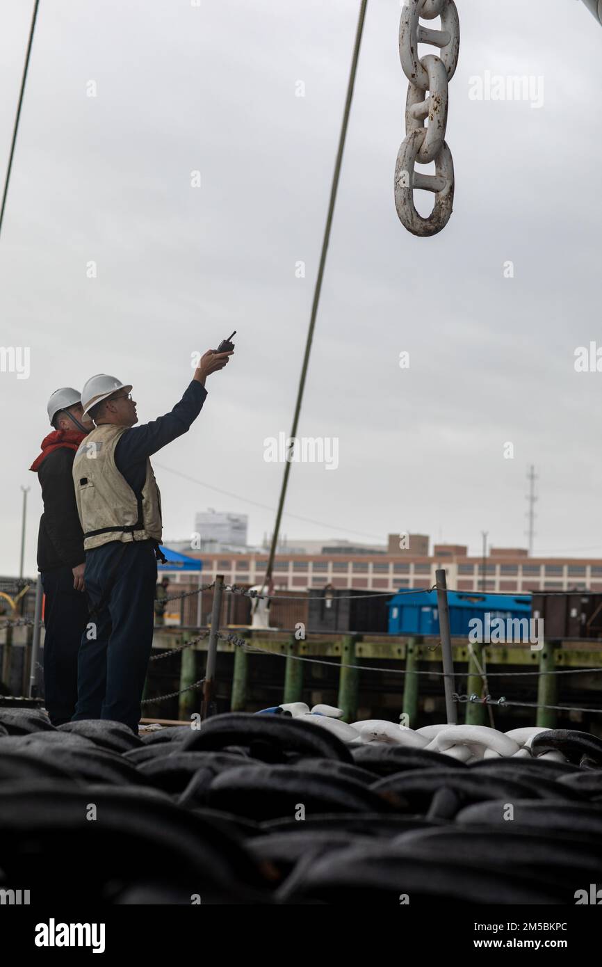 220223-N-HA192-1060 NORFOLK, VIRGINIA. (23 febbraio 2022) - i marinai assegnati alla nave d'assalto anfibio USS Bataan (LHD 5) effettuano il mantenimento della conservazione sulla catena di ancoraggio lato porto 23 2022 febbraio. Bataan è casa presso la Naval Station Norfolk. Foto Stock