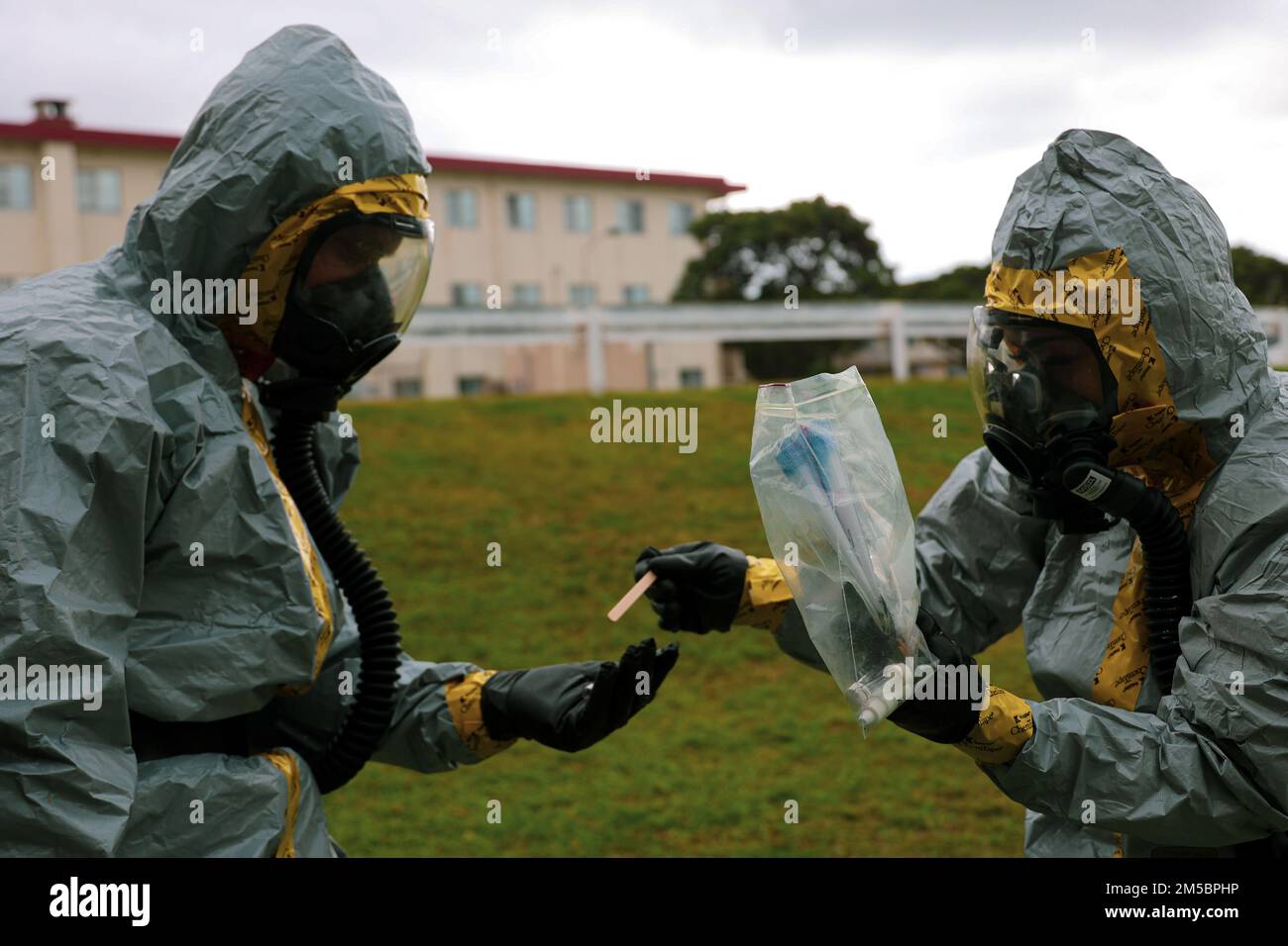STATI UNITI Il personale del corpo marino Sgt. Demetri Duey, a sinistra, e Sgt. Lena Huynh, a destra, entrambi i tecnici di smaltimento di ordigni esplosivi assegnati a Marine Wing Support Squadron (MWSS) 172 conducono la formazione basata sullo scenario presso Marine Corps Air Station Futenma, Okinawa, Giappone, 24 febbraio 2022. La difesa chimica, biologica, radiologica e nucleare (CBRN) è responsabile della formazione e della ricognizione, dell'identificazione del rilevamento chimico, della raccolta e del campionamento degli agenti biologici, della decontaminazione del personale, delle apparecchiature e degli incidenti e delle misure di protezione individuale per il personale dell'unità. Foto Stock
