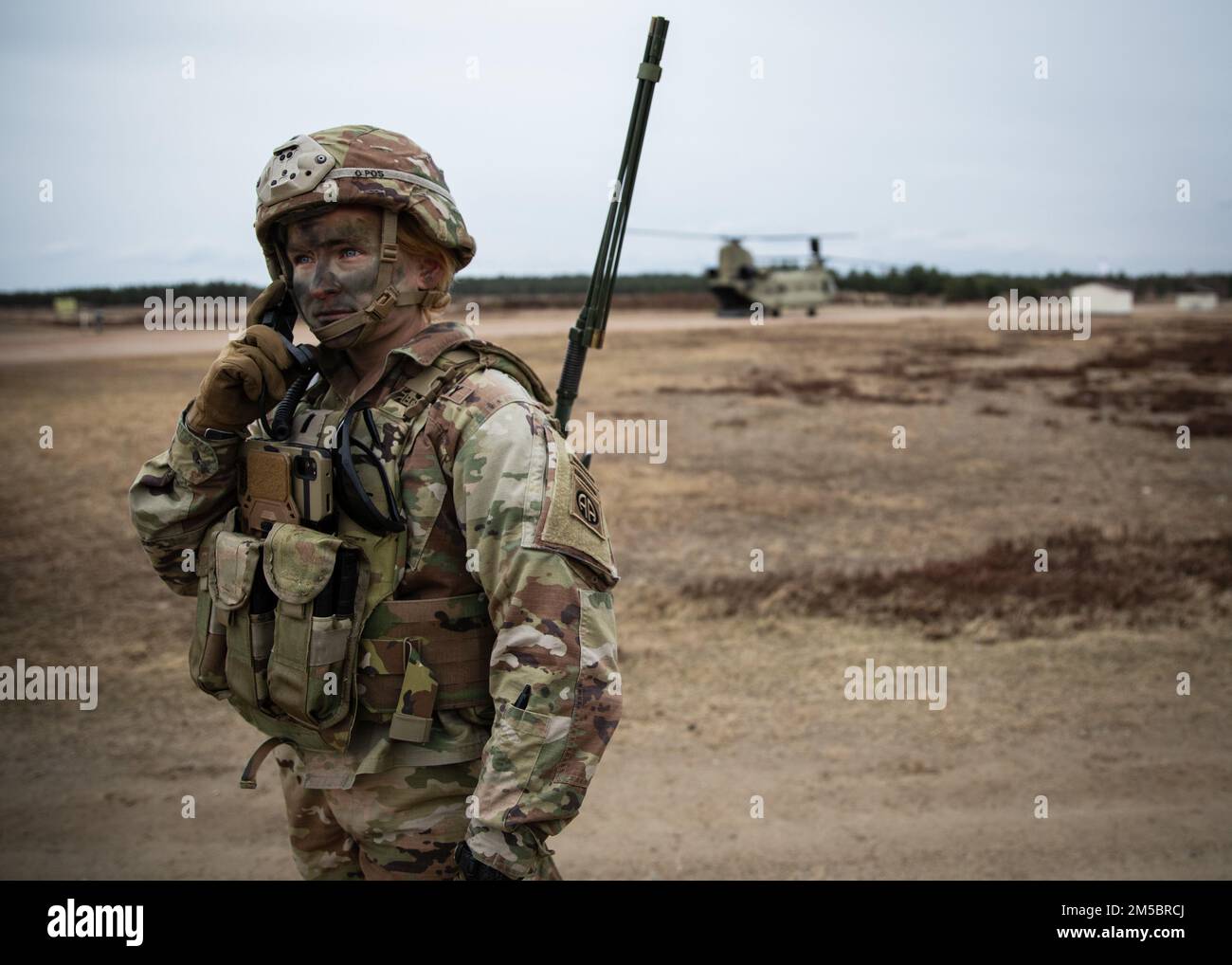 Ufficiale assegnato a 3rd Brigade Combat Team, 82nd Airborne Division comunica via radio con un elicottero CH-47 Chinook durante un evento combinato a Nowa Deba, Polonia, 25 febbraio 2022. L'obiettivo della missione della 82nd Airborne Division è quello di assicurare i nostri alleati fornendo una serie di capacità uniche e conducendo un'ampia gamma di missioni scalabili e adattabili alle esigenze della missione. Foto Stock