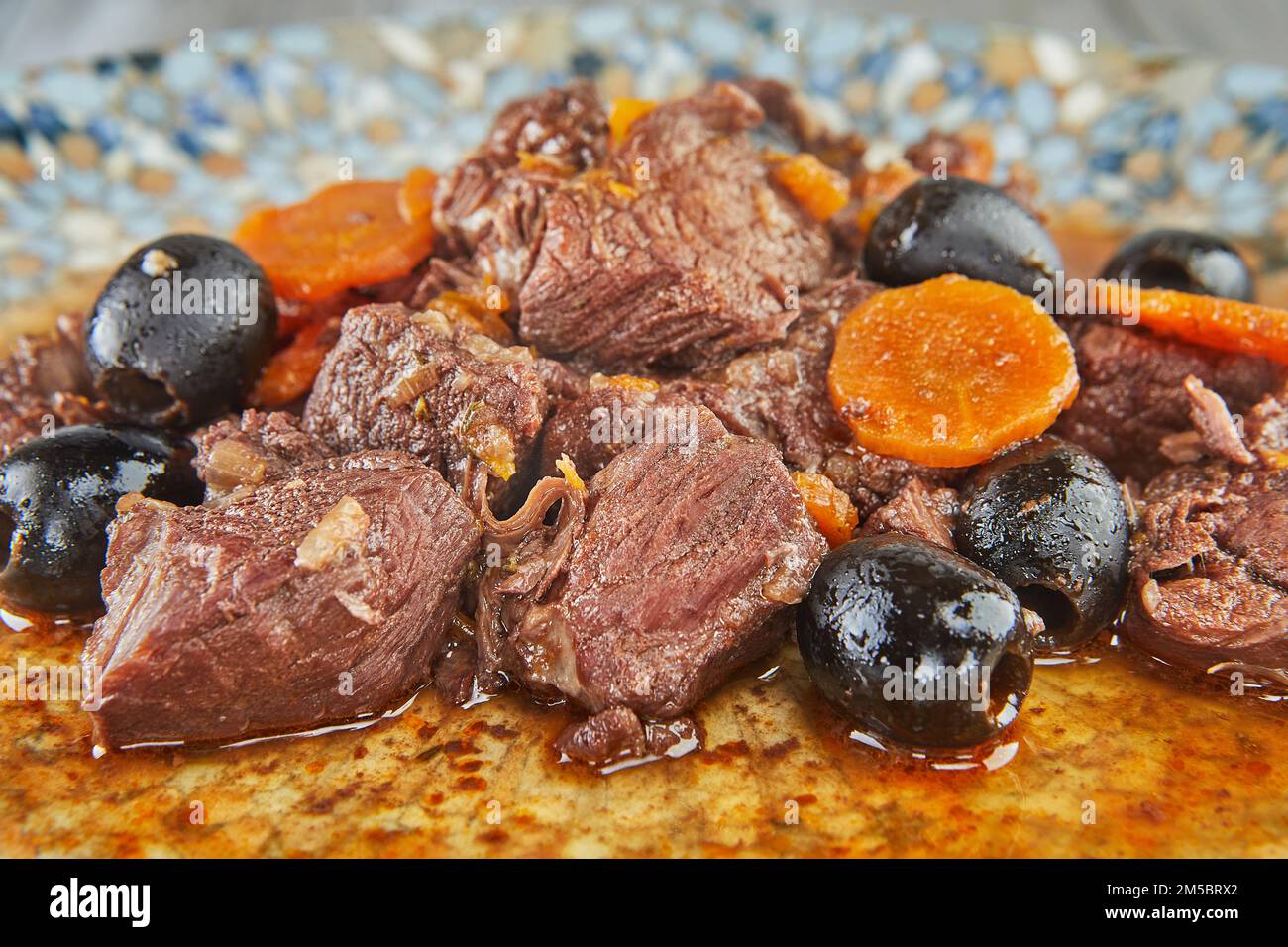 Stufato di carne di daub provenzale su piatto su sfondo di legno Foto Stock