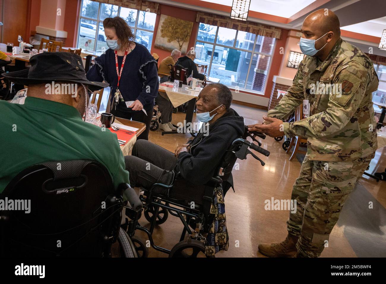 STATI UNITI Il personale dell'aeronautica militare Edward D. Simms, 204th Intelligence Squadron, 108th Wing, New Jersey Air National Guard, assiste James Dow, residente presso la New Jersey Veterans Memorial Home di Vineland, nella sala da pranzo della casa a Vineland, New Jersey, 24 febbraio 2022. Simms sta servendo i residenti della casa nel Dipartimento di arricchimento della vita. Più di 70 soldati della Guardia Nazionale del New Jersey e Airmen stanno servendo come assistenti infermieristici certificati e in servizi alimentari, controllo delle infezioni, tecnologia dell'informazione, arricchimento della vita, Logistica, E COVID-19. (Foto della Guardia Nazionale del New Jersey di Mark C. Foto Stock