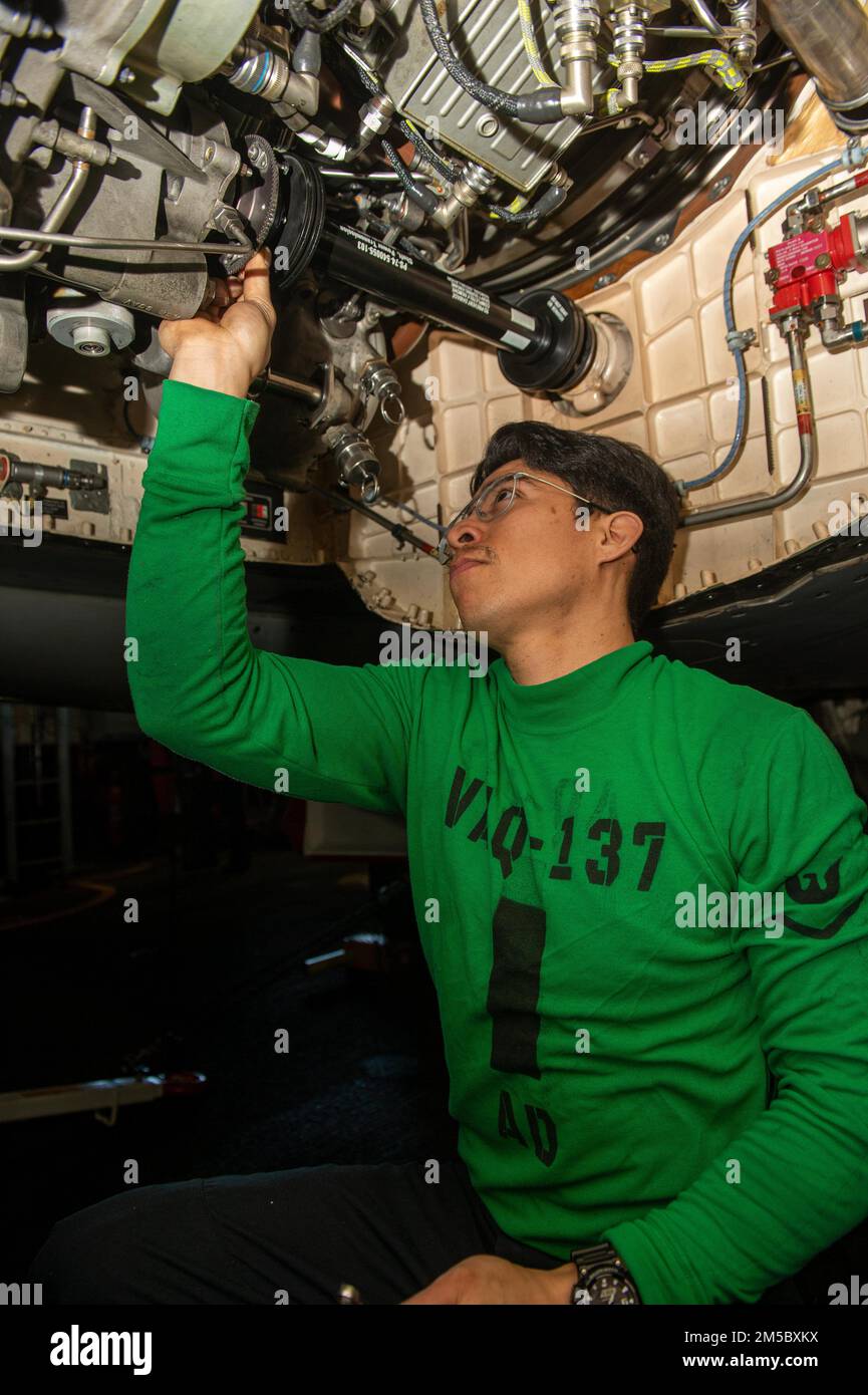 220225-N-PG226-1012 IONIAN SEA (25 febbraio 2022) Aviation Machinist's Mate 3rd Class Christopher Estrella, di Oceanside, California, assegnato ai 'Rook' di Electronic Attack Squadron (VAQ) 137, rimuove un albero di trasmissione di potenza da un EA-18G Growler nella baia hangar del portaerei di classe Nimitz USS Harry S. Truman (CVN 75) 25 febbraio 2022. Il gruppo Harry S. Truman Carrier Strike Group è in fase di implementazione pianificata negli Stati Uniti Sesta area di attività Fleet a sostegno degli interessi degli Stati Uniti, alleati e partner in Europa e Africa. Foto Stock
