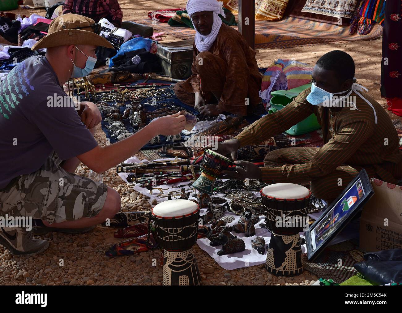 NEGLI STATI UNITI Il membro di servizio acquista un tamburo durante un bazar alla base aerea nigerien 201, Agadez, Niger 27 febbraio 2022. I membri del servizio degli Stati Uniti hanno acquistato circa 10.532.000 franchi CFA dell'Africa occidentale ($18K USD) di merci durante il bazar. Eventi come questi migliorano le relazioni tra Stati Uniti e Niger e stimolano lo sviluppo economico locale. Foto Stock