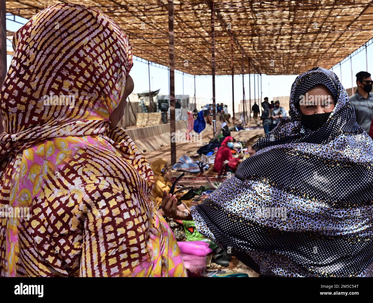 STATI UNITI Maribel Seegmiller (a destra), 724th base aerea espeditativa Squadron direttore delle operazioni, prova su un abito tradizionale africano durante un bazar alla base aerea nigerien 201, Agadez, Niger, 27 febbraio 2022. Oltre 40 venditori locali dalla città di Agadez e villaggi circostanti hanno frequentato il bazar, vendendo vari beni. I membri del servizio negli Stati Uniti hanno acquistato una merce del valore di circa 10.532.000 franchi CFA dell'Africa occidentale ($18K USD). Eventi come questi migliorano le relazioni tra Stati Uniti e Niger e stimolano lo sviluppo economico locale. Foto Stock