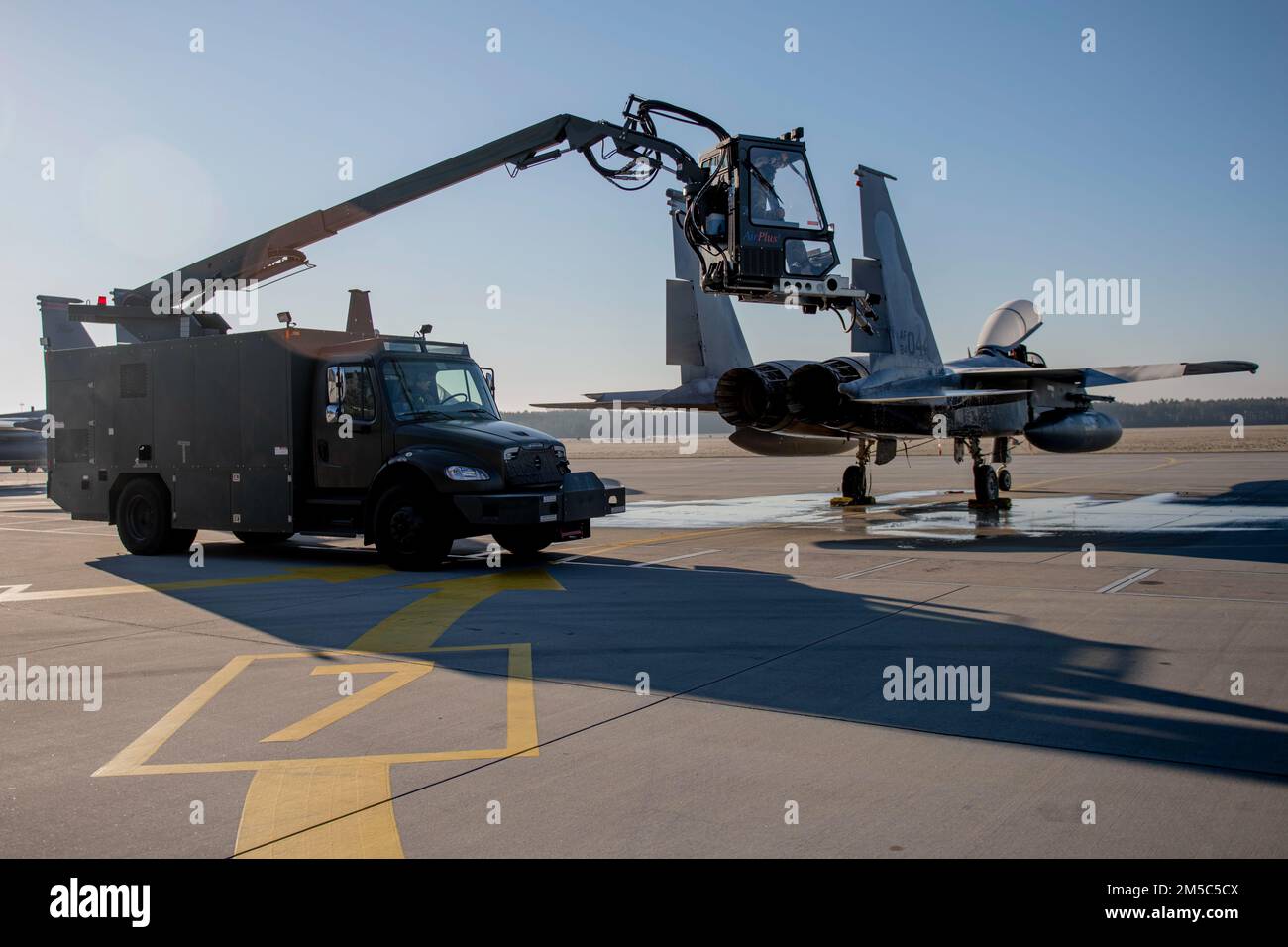 STATI UNITI Air Force Airmen assegnato al 748th Aircraft Maintenance Squadron prepararsi a disgelare un US Air Force F-15C Eagle assegnato al 493rd Fighter Squadron, dalla Royal Air Force base Lakenheath, a Łask Polonia, 28 febbraio 2022. Lo sbrinatore assicura che l'aeromobile sia privo di ghiaccio o neve, consentendo all'aeromobile di mantenere i propri parametri aerodinamici nelle operazioni invernali. Foto Stock