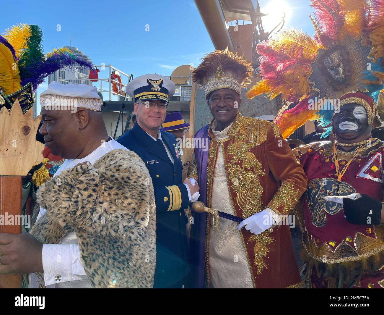 Richard Timme, ottavo comandante della Guardia Costiera (a sinistra), scuote le mani con il King of Zulu Social Aid and Pleasure Club a bordo degli Stati Uniti Guardia costiera Cutter Barbara Mabrity 28 febbraio 2022. La Guardia Costiera ha partecipato alla celebrazione del Lundi Gras del 2022 fornendo il trasporto per il club. ( STATI UNITI Guardia costiera foto di Petty ufficiale 3rd classe James Hague) Foto Stock