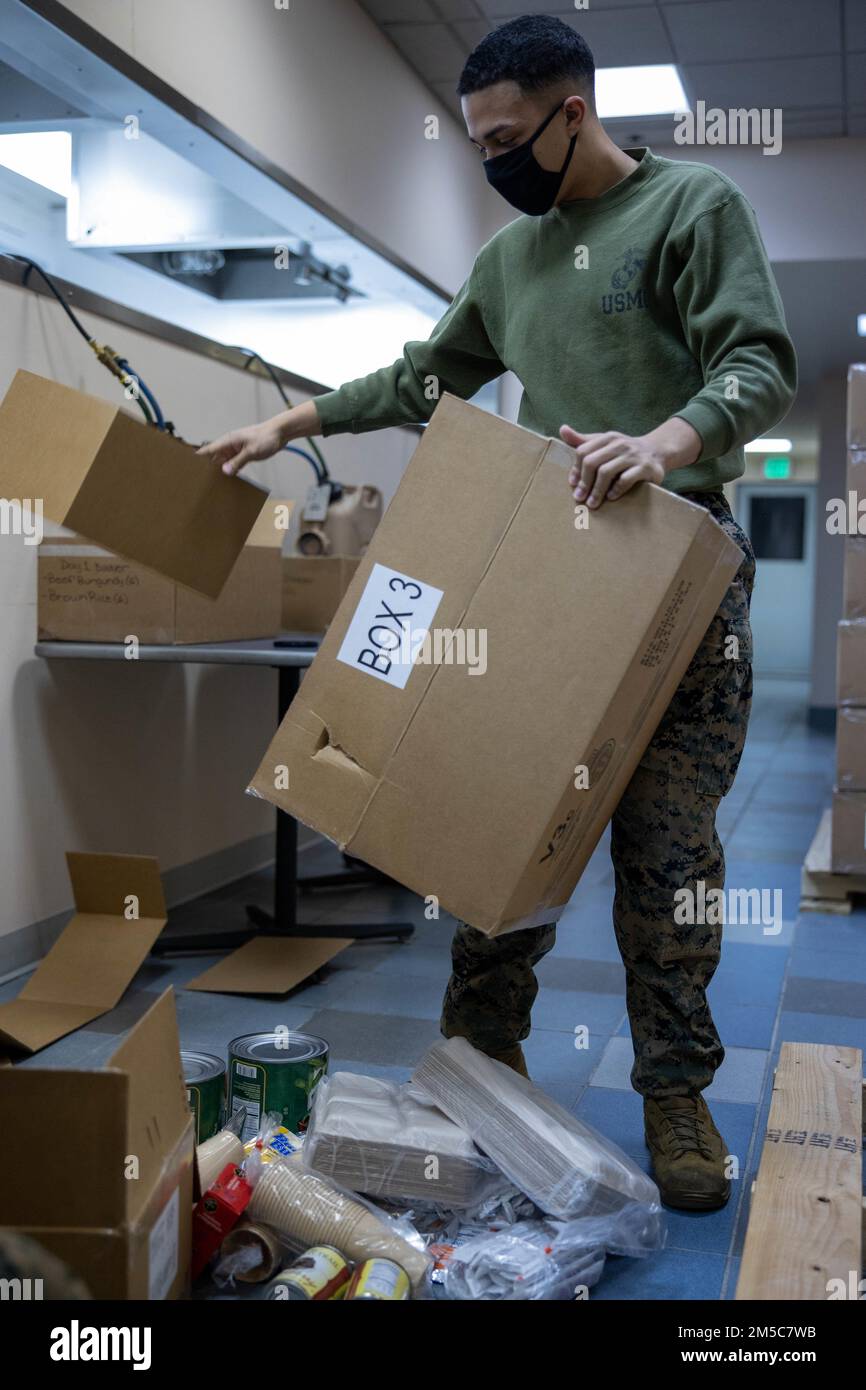 STATI UNITI Cameron Yan, uno specialista di alimenti con 2nd Battaglione di trasporto, svuota le scatole unitizzate di razione dell'alimento prima di organizzarle nei pasti per gli Stati Uniti Soldati dell'esercito che partecipano all'Arctic Edge 22, all'Aurora Event Center sulla base dell'aeronautica militare di Eielson, Fairbanks, Alaska, 28 febbraio 2022. 2nd LSB fornisce un ruolo di supporto critico durante l'esercitazione Arctic Edge 22, fornendo servizi alimentari a tutti i soldati che partecipano all'addestramento alle basse temperature. Foto Stock