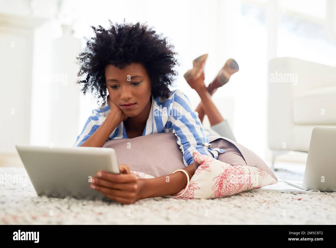 Portalo a casa con facilità. una giovane donna che usa un tablet digitale a casa. Foto Stock