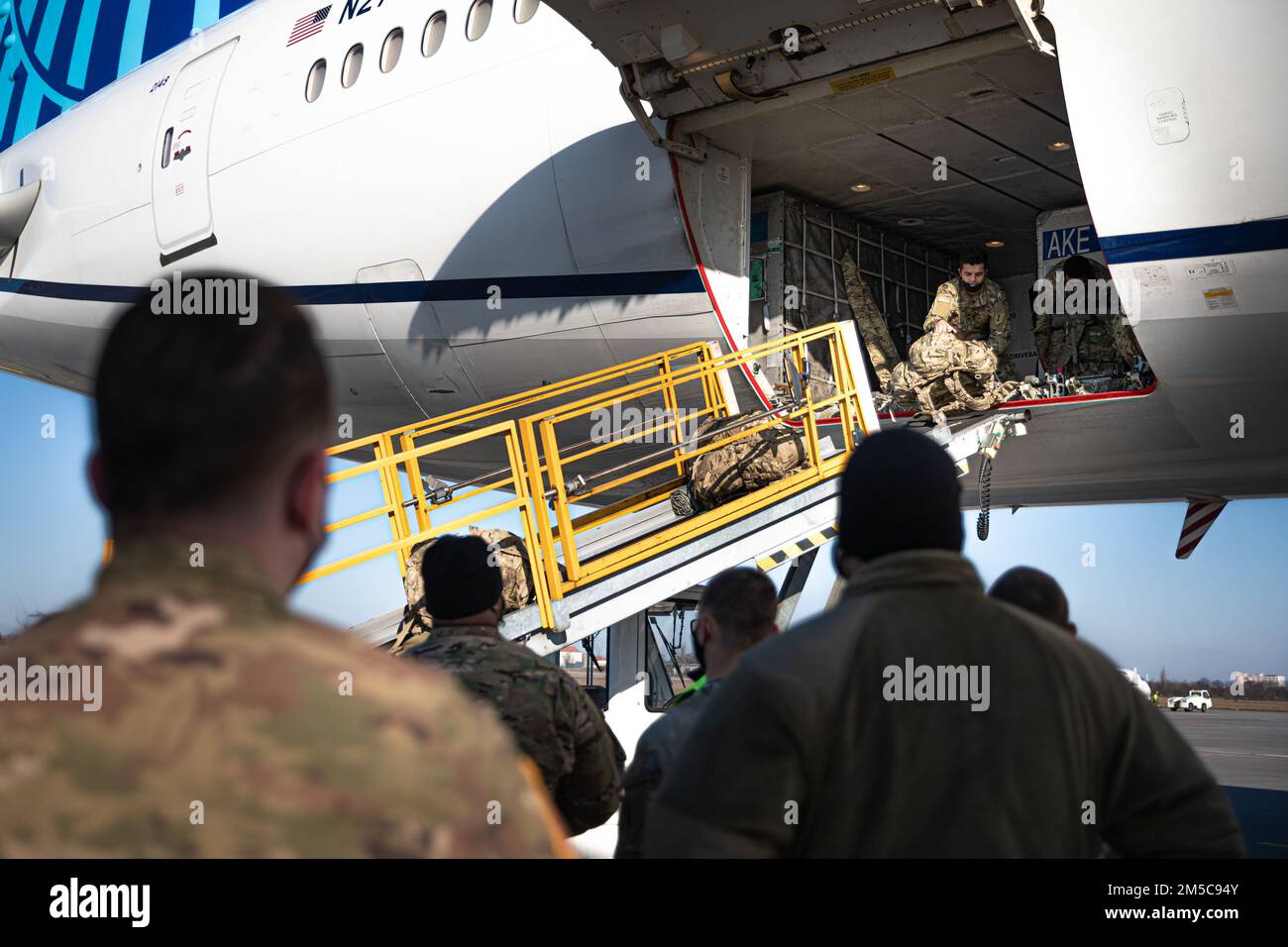 STATI UNITI I soldati assegnati alla 1st° Divisione Fanteria scaricano le borse da duffle dal loro aereo dopo essere arrivati in Polonia, il 28 febbraio 2022. I membri del servizio erano lì per sostenere la preparazione e la difesa collettiva della NATO. Foto Stock