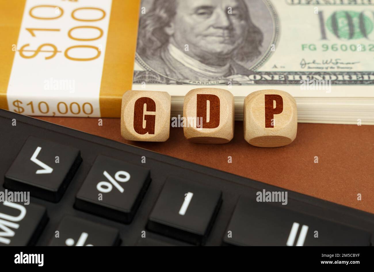 Concetto aziendale. Sulla tabella sono i dollari, una calcolatrice e cubi con l'iscrizione - PIL Foto Stock