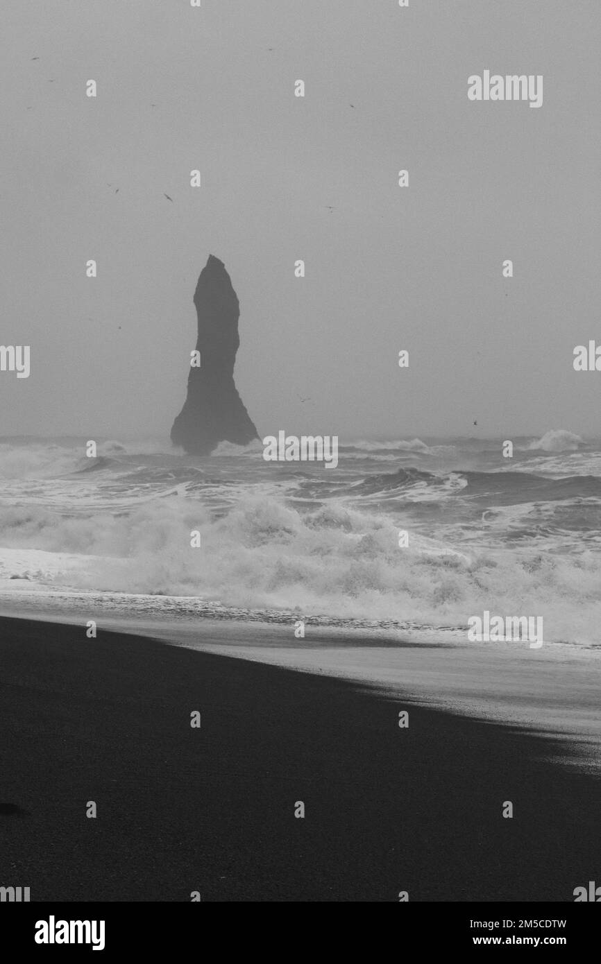 Alta scogliera sulla spiaggia Islanda paesaggio monocromatico foto Foto Stock
