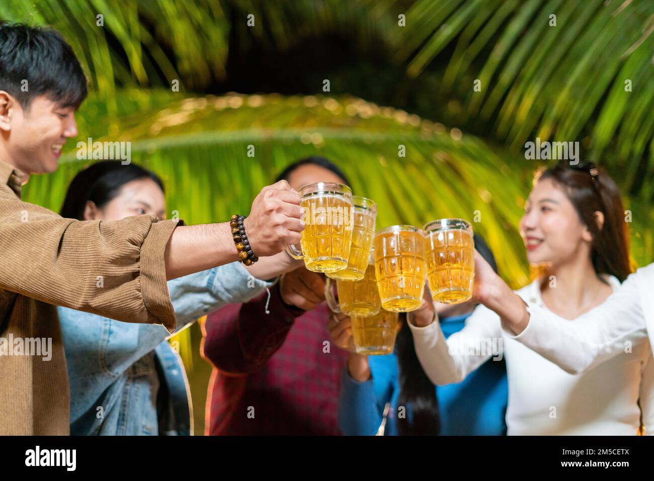 Gruppo di amici che brinda felicemente le birre Foto Stock