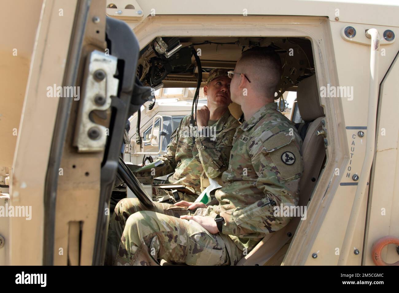 Jason A. W. Lansbury, un operatore di trasporto a motore assegnato al comando di supporto spedizione 3rd, mostra Brig. Lance G. Curtis, vice generale comandante per il 1st° comando di sostegno al teatro, e il generale comandante del 3rd° ESC, cabina del generale Mine Resistant Ambush Vehicle a Camp Arifjan, Kuwait, il 1 marzo 2022. Il generale ha visitato la piscina per interagire con i soldati e per valutare la disponibilità delle attrezzature dell'unità. Foto Stock