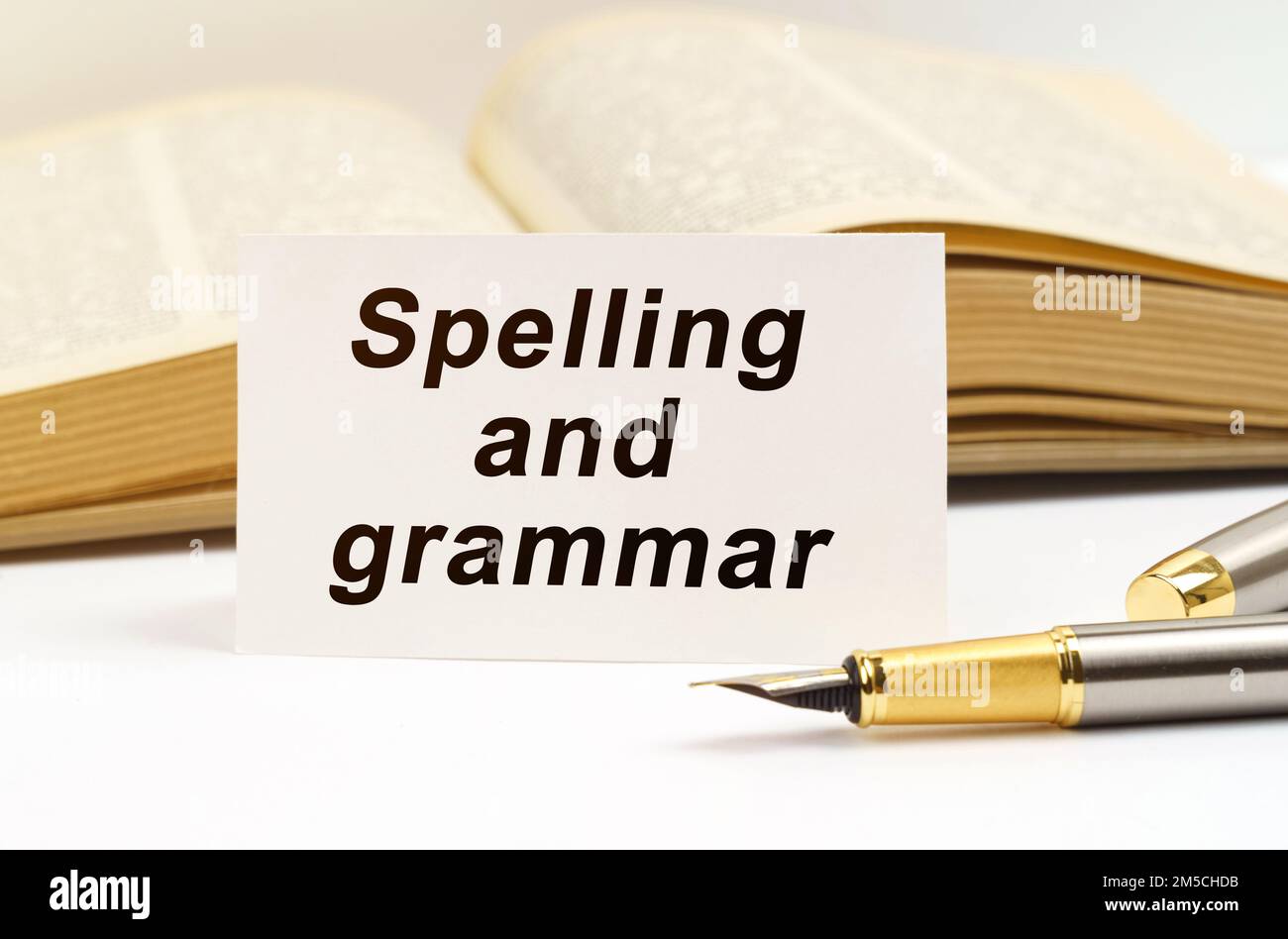 Concetto di istruzione. Sullo sfondo del libro si trova una penna e un biglietto da visita con l'iscrizione - ortografia e grammatica Foto Stock