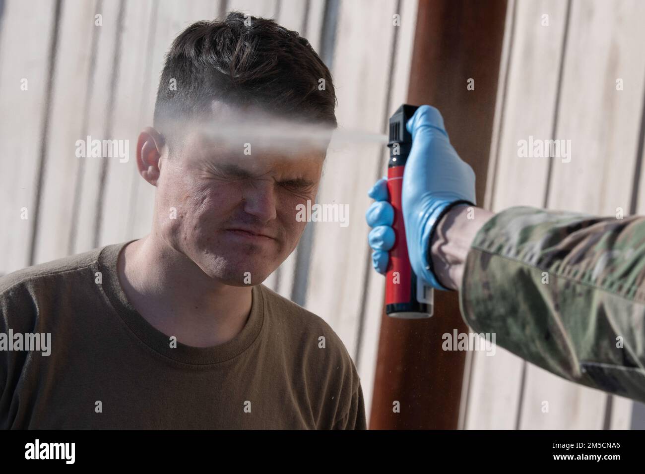 STATI UNITI Air Force Senior Airman Christopher Ricks, un controller di ingresso per l'installazione di 673d Security Forces Squadron, è contaminato da oleoresin capsicum (OC) durante l'addestramento alla familiarizzazione presso la base congiunta Elmendorf-Richardson, Alaska, 2 marzo 2022. Tutto il personale delle forze di sicurezza è esposto a spray OC per familiarizzare con i suoi effetti dolorosi e come operare quando è contaminato. OC spray è un'arma non letale usata per inabilitare individui non cooperativi. Foto Stock