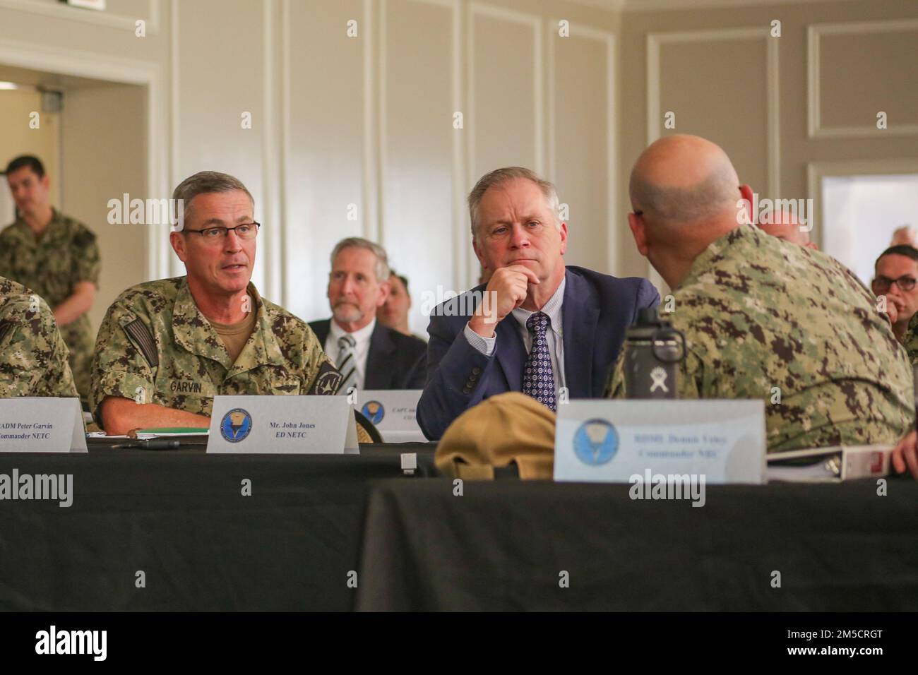 PENSACOLA, Fla. (2 marzo 2022) posteriore ADM. Pete Garvin, comandante, Naval Education and Training Command (NETC), a sinistra, e NETC Executive Director John Jones, al centro, ascoltare posteriore ADM. Dennis Velez, comandante, Navy Recruiting Command, durante la primavera NETC off-site alla Naval Air Station Pensacola. L'incontro è stato un'opportunità per la leadership di dominio NETC/MyNavy HR Force Development di discutere una serie di priorità e questioni che si estendono attraverso la missione "strada per la flotta" di reclutamento, formazione e consegna di combattenti pronti per il combattimento alla flotta. Foto Stock