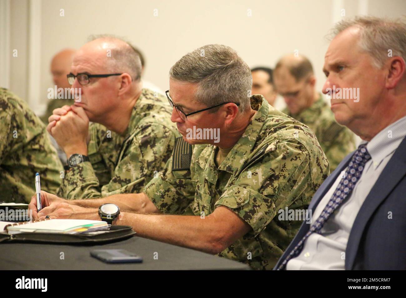 PENSACOLA, Fla. (2 marzo 2022) posteriore ADM. Pete Garvin, comandante, Naval Education and Training Command (NETC), centro, prende appunti mentre ascolta una breve presentazione durante la PRIMAVERA NETC fuori sede presso la Naval Air Station Pensacola. L'incontro è stato un'opportunità per la leadership di dominio NETC/MyNavy HR Force Development di discutere una serie di priorità e questioni che si estendono attraverso la missione "strada per la flotta" di reclutamento, formazione e consegna di combattenti pronti per il combattimento alla flotta. Foto Stock