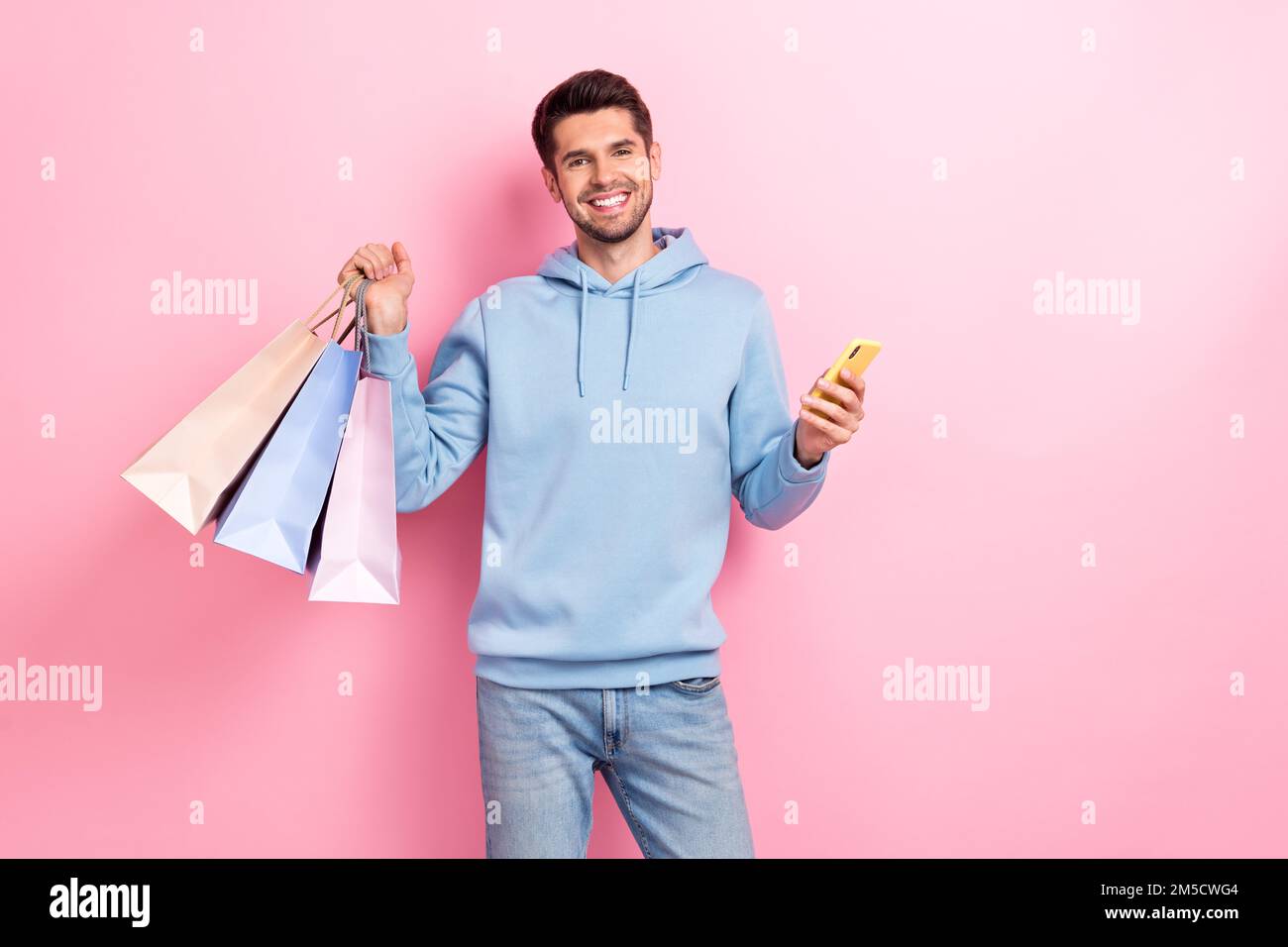 Foto di buon umore ragazzo positivo vestito blu felpa acquisto occasioni  instagram facebook negozio isolato colore sfondo rosa Foto stock - Alamy