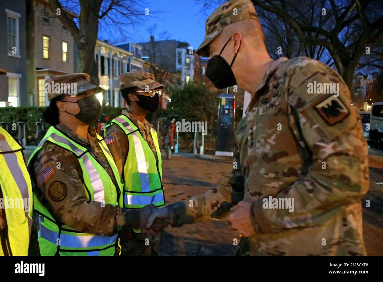 Tiffany Etheredge, sinistra, 508th Società di polizia militare, 42nd Regional Support Group, New Jersey National Guard, riceve una moneta dagli Stati Uniti Daniel R. Hokanson, capo del National Guard Bureau, in un punto di controllo del traffico nel Distretto di Columbia, 2 marzo 2022. Hokanson visitò diversi TPC per ringraziare i soldati del New Jersey, Vermont e West Virginia per aver assistito il D.C. Guardia Nazionale che sostiene il D.C. Metropolitan Police Department e U.S. Polizia del Campidoglio con controllo del traffico in previsione delle prime dimostrazioni di Emendamento nella Regione del Campidoglio. Foto Stock