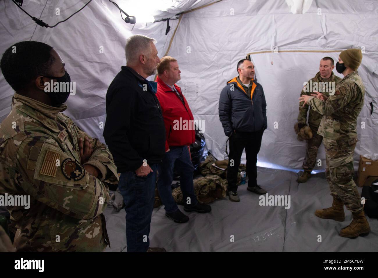 1st il Lt. Whitney Galloway (a destra) spiega le capacità artiche della tenda medica mobile ai visitatori illustri in Nome, Alaska, Mar. 2. Esercitazione Arctic Eagle-Patriot 2022 aumenta la capacità della Guardia Nazionale di operare in ambienti austeri e con temperature estremamente basse in tutta l'Alaska e la regione artica. AEP22 migliora la capacità dei partner tra agenzie militari e civili di rispondere a una serie di missioni di sicurezza in Alaska e nell'Artico. Foto Stock