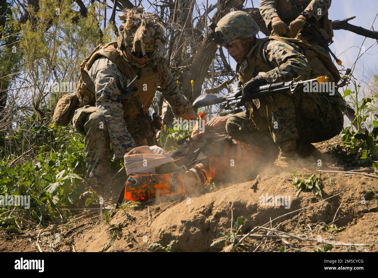 STATI UNITI Marine Corps Sgt. Greg Granby, un mortarman con la compagnia di armi, 2D battaglione, 5th Marines (2/5), 1st Divisione Marina, E Lance CPL. Andy Flores Jr., uno specialista di combattimento e salvataggio di spedizione con Marine Wing Support Squadron 372, Marine Aircraft Group 39, 3D Marine Aircraft Wing, trasportare un incidente simulato durante un recupero tattico di aerei e personale (TRAPPOLA) corso a Marine Corps base Camp Pendleton, California, 2 marzo 2022. I Marines del 2/5 hanno partecipato al corso TRAP per acquisire competenze in operazioni di ricerca e salvataggio rapide. Foto Stock