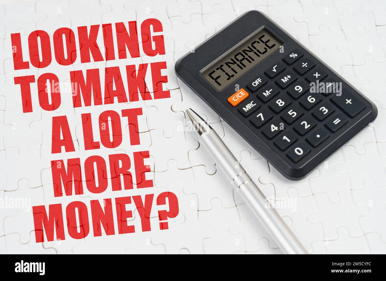 Concetto aziendale. Sui puzzle si trova una calcolatrice e una penna, accanto all'iscrizione - cercando di fare un lotto di denaro in più Foto Stock