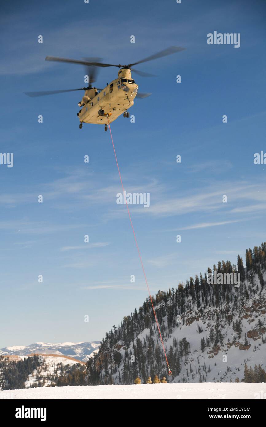 Gli equipaggi della Guardia Nazionale dell'esercito dello Utah e del Nevada preparano un elicottero UH-60 Black Hawk per il trasporto aereo il 2 marzo 2022, vicino alla stazione sciistica di Snowbird nello Utah. Due elicotteri Black Hawk che sono stati coinvolti in un incidente la settimana precedente sono stati caricati da una guardia nazionale dell'esercito del Nevada CH-47 Chinook e trasportati all'aeroporto di Heber Valley, Heber City, Utah. Foto Stock